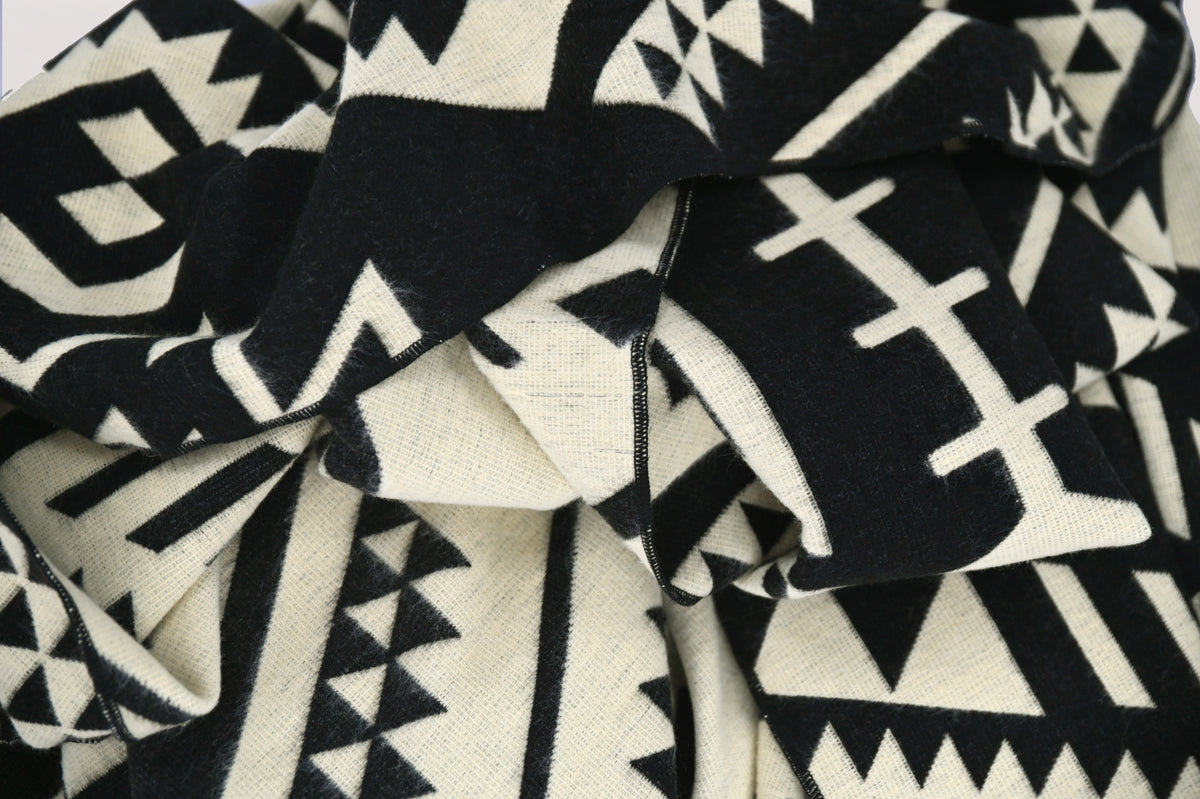 Zwart-beige geometrisch patroon en plooien van de omkeerbare alpacadeken