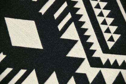 Close-up van het krachtige zwart-beige geometrische patroon en de geweven alpacatextuur