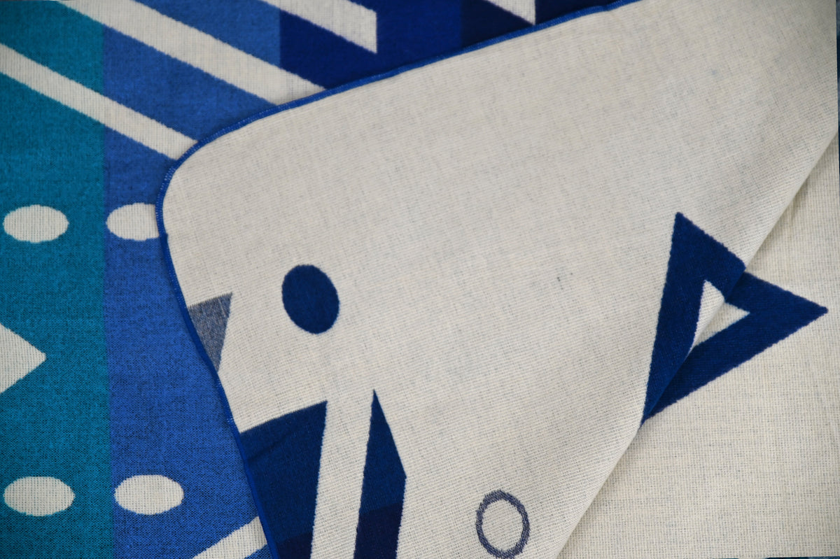 Reverse side of the Aztec Blue Geometric alpaca blanket with ivory and blue geometric details