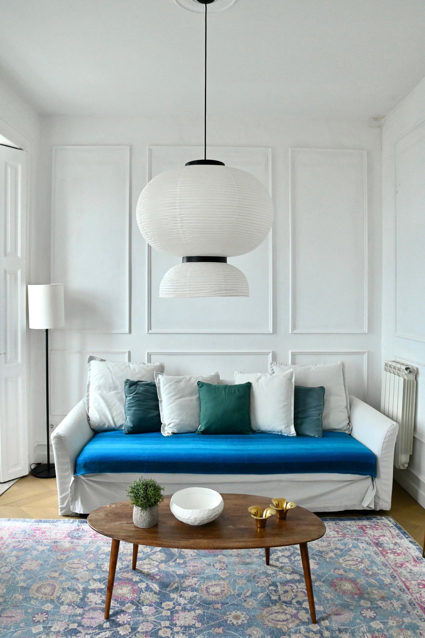 Modern living room with a blue alpaca blanket on sofa, wooden coffee table, and decorative items.