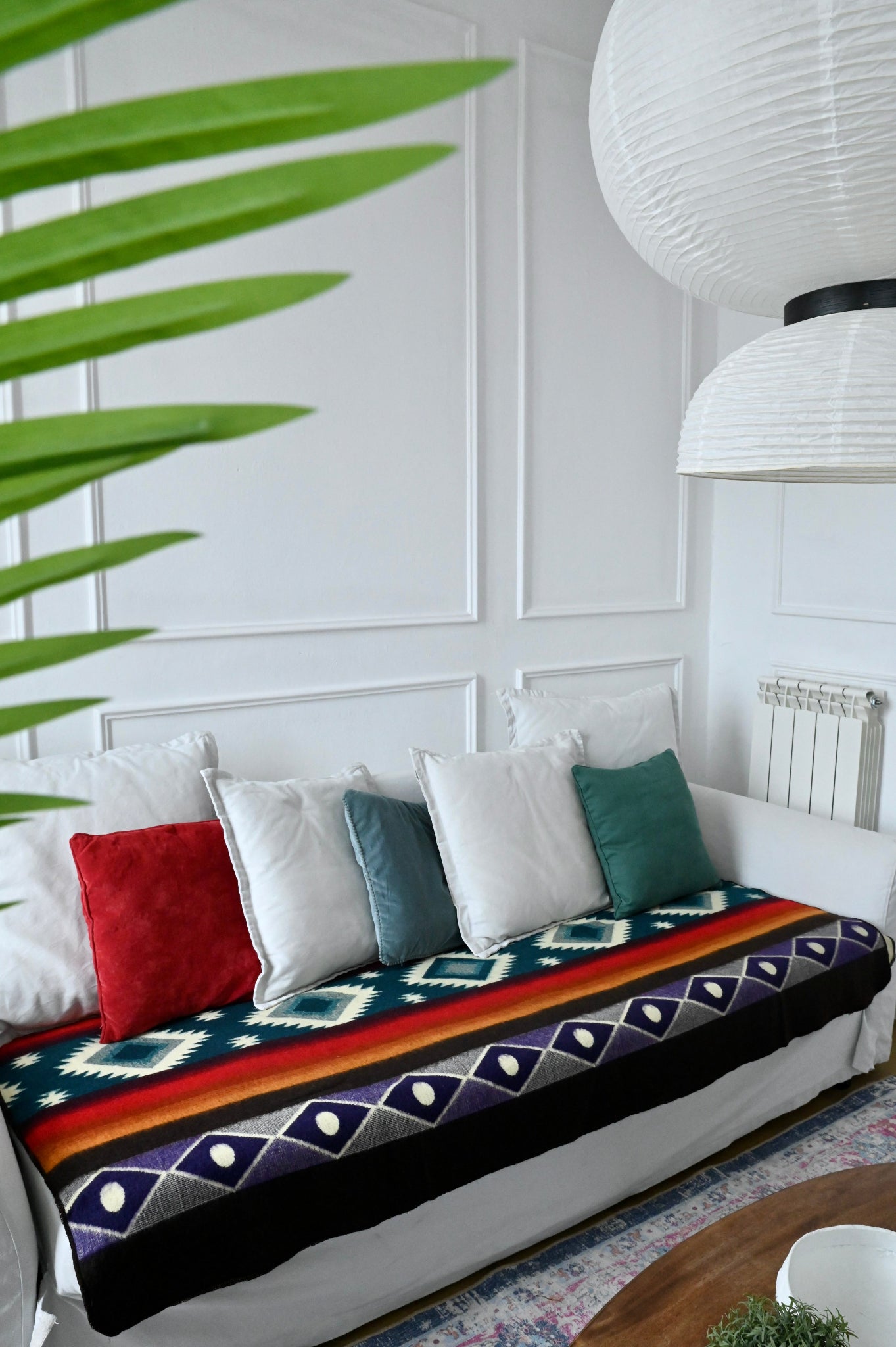 White sofa with colorful alpaca blanket and pillows in a living room setting