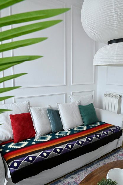 White sofa with colorful alpaca blanket and pillows in a living room setting