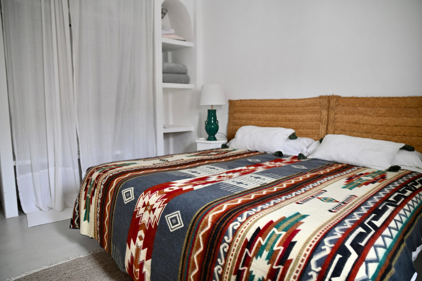 Bed with patterned alpaca blanket in a bedroom setting