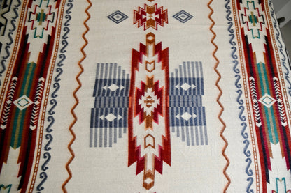 Close-up of a patterned alpaca blanket with geometric designs on a beige background