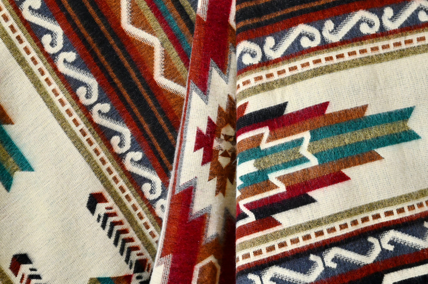 Close-up of a patterned alpaca blanket with geometric designs in red, blue, and white.