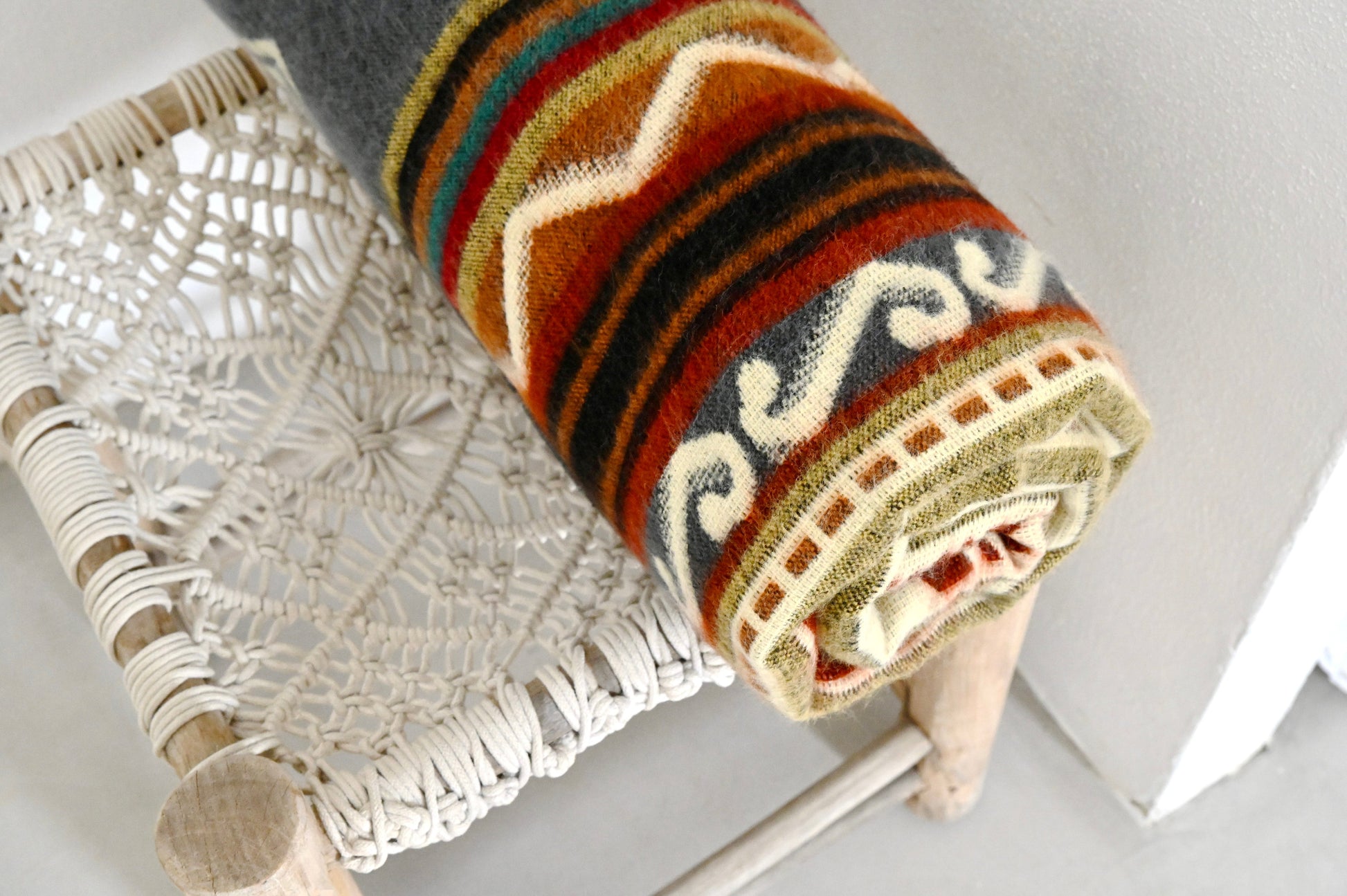 Textured fabric roll with intricate patterns on a white surface