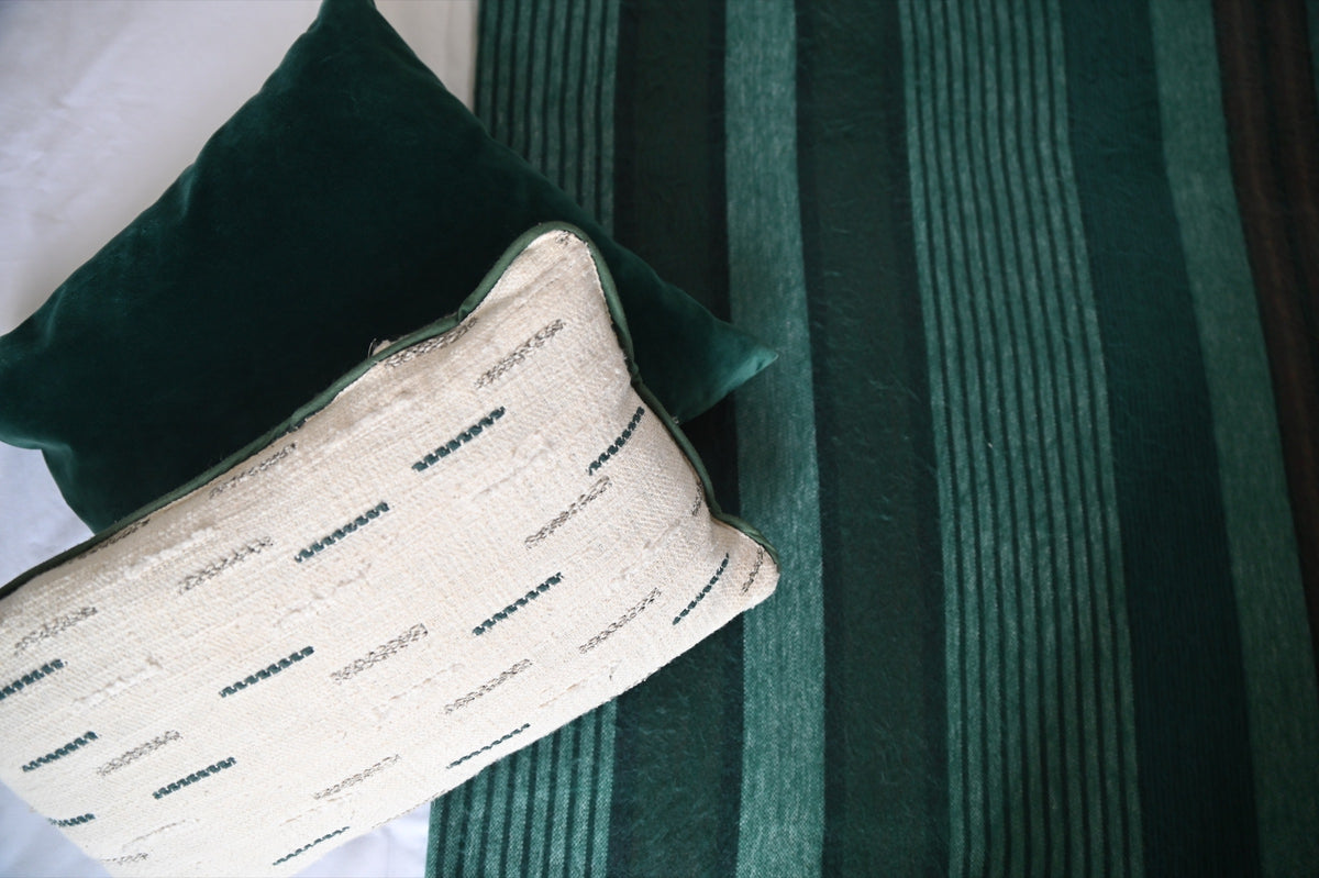 Emerald Forest striped alpaca blanket with decorative bedroom cushions
