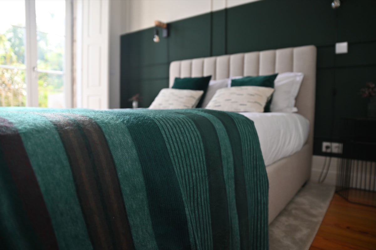 Close-up of the Emerald Forest alpaca blanket on a bed