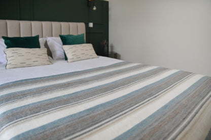Foggy Coast striped alpaca wool blanket spread across a bed