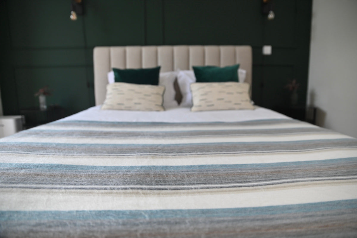 Foggy Coast alpaca wool blanket arranged across a modern bed