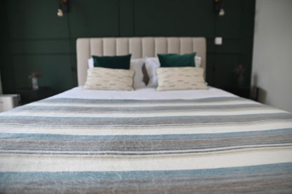 Foggy Coast alpaca wool blanket arranged across a modern bed