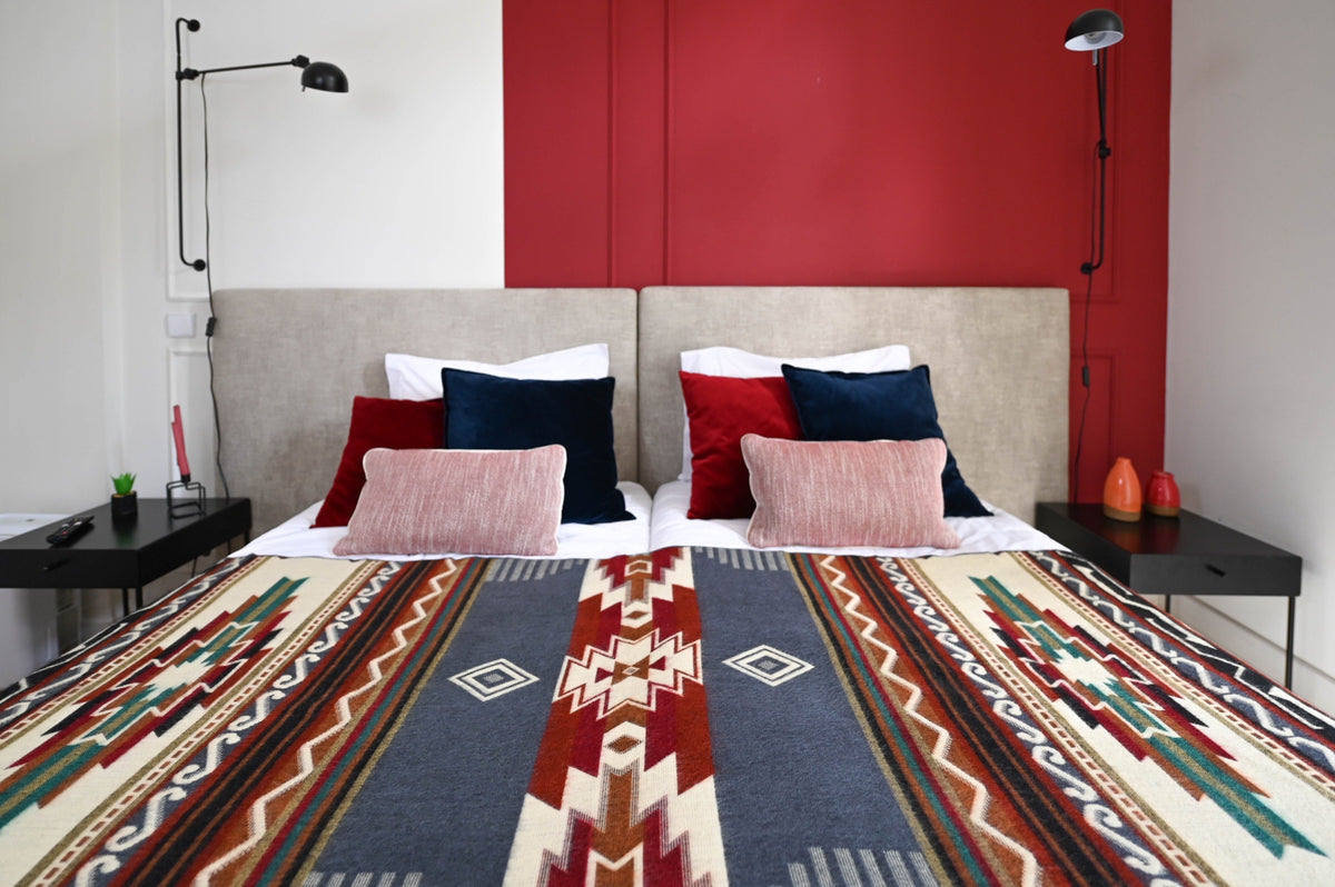 Andean Horizon Aztec alpaca blanket spread across a twin bed