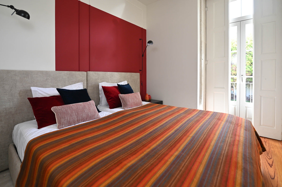 Autumn Sunset striped alpaca blanket styled in a bright bedroom