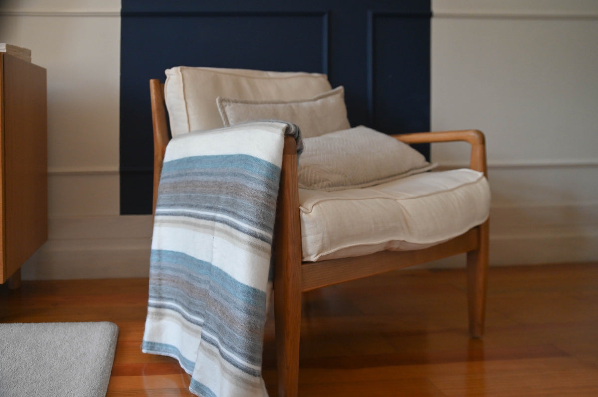 Foggy Coast alpaca blanket draped over a wooden armchair