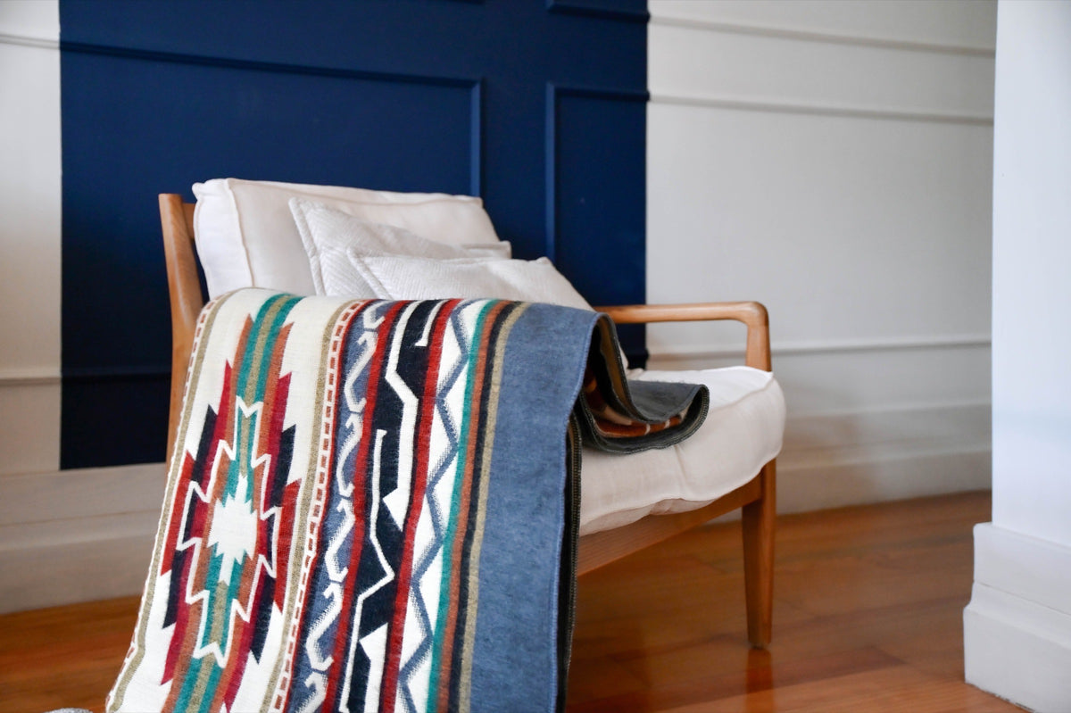 Andean Horizon alpaca blanket draped over a wooden armchair