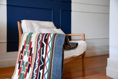 Andean Horizon alpaca blanket draped over a wooden armchair